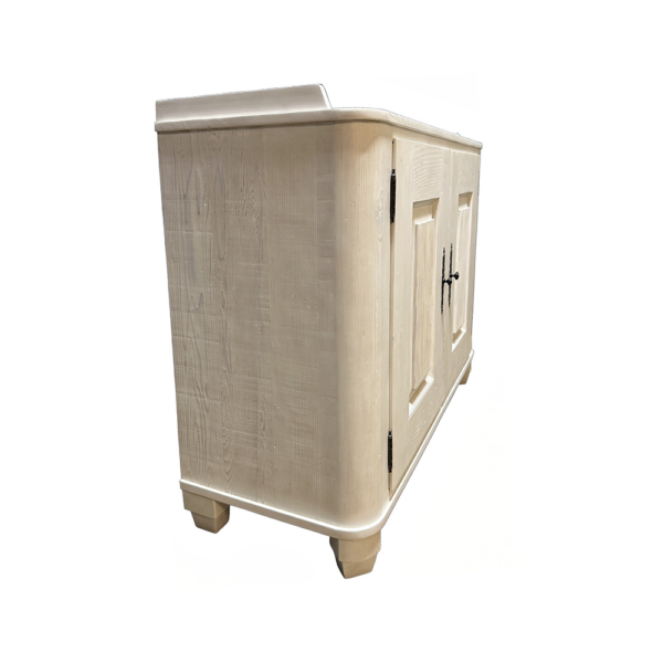 Cream-colored freestanding wooden cabinet with two paneled doors and black handles on short feet, used for storage.